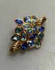 Yves Saint Laurent brooch in gold metal set with blue and green stones, vintage 1970, very good condition